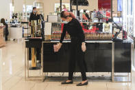 A worker inside a retail department store wipes down a cosmetics display shelf in Melbourne, Australia, Wednesday, Oct. 28, 2020. Australia’s second largest city of Melbourne which was a coronavirus hotspot emerges from a nearly four-months lockdown, with restaurants, cafes and bars opening and outdoor contact sports resuming on Wednesday. (AP Photo/Asanka Brendon Ratnayake)