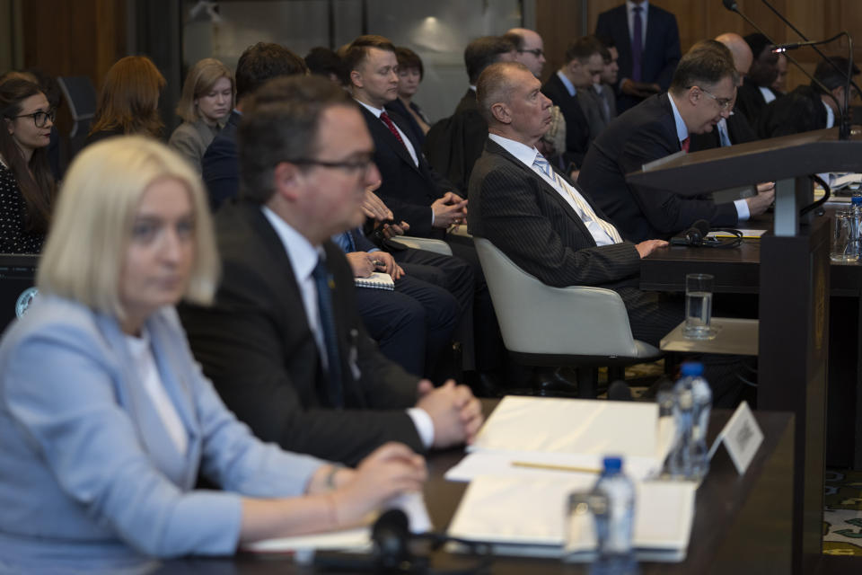 Ukraine's delegation with ambassador-at-large of the ministry of foreign affairs Anton Korynevych, second left, and Russia's delegation with Gennnady Kuzmin, ambassador-at-large of the ministry of foreign affairs, third from left, wait for judges to enter the World Court in The Hague, Netherlands, Tuesday, June 6, 2023. Four days of hearings open in a case brought by Ukraine against Russia at the UN's top court alleging that Russia breached treaties on terrorist financing and racial discrimination in eastern Ukraine and Crimea. (AP Photo/Peter Dejong)