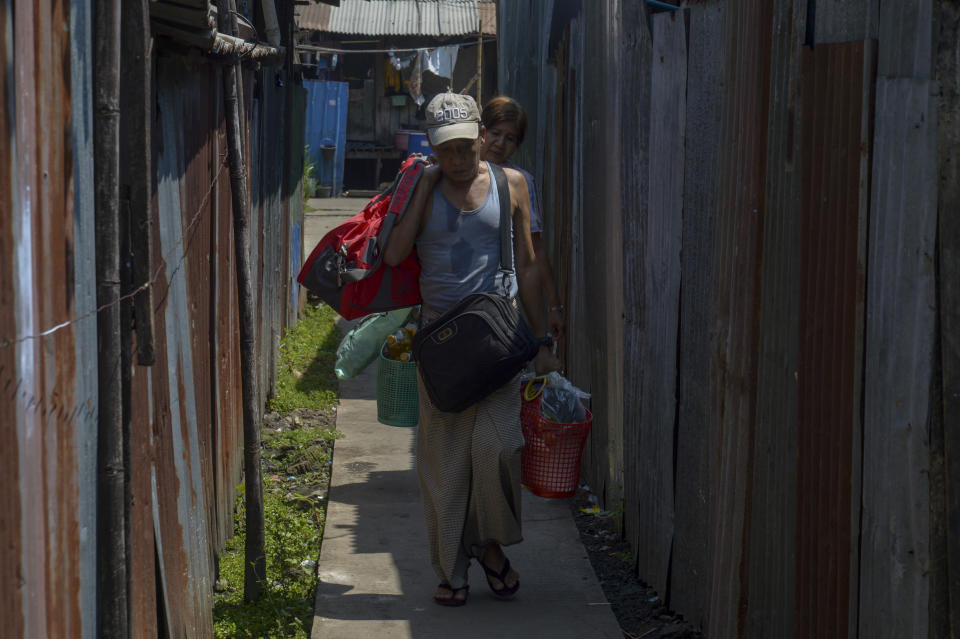 Railway workers, participants of a "civil disobedience movement" (CDM) against the military takeover of power, leave their government provided houses with their belongings in Yangon, Myanmar Wednesday, March 10, 2021. Armed soldiers and riot policemen arrived in the morning and ordered the workers and their families who participate in the CDM to vacate their housing. (AP Photo)