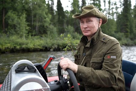 Russian President Vladimir Putin controls a boat during the hunting and fishing trip which took place on August 1-3 in the republic of Tyva in southern Siberia, Russia, in this photo released by the Kremlin on August 5, 2017. Sputnik/Alexei Nikolsky/Kremlin via REUTERS