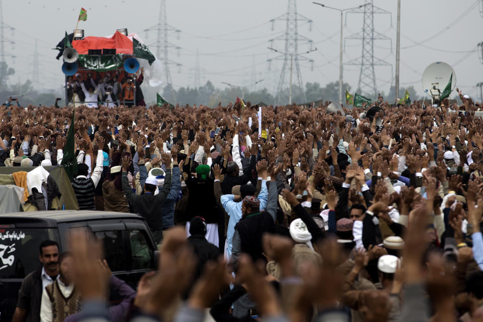 FILE - In this Nov. 24, 2017, file photo, people raise their hands to express their support for Khadim Hussain Rizvi, leader of the radical political party, Tehreek-i-Labbaik Ya Rasool Allah, during an anti-government protest in Islamabad, Pakistan. Terror attacks in Pakistan plummeted by more than 85% over the last decade. It's a welcome statistic for the country, but one that risks being overshadowed by international concern over its efforts to curb terror funding and lingering militant activity that could test any future peace agreement in Afghanistan. (AP Photo/B.K. Bangash,file)