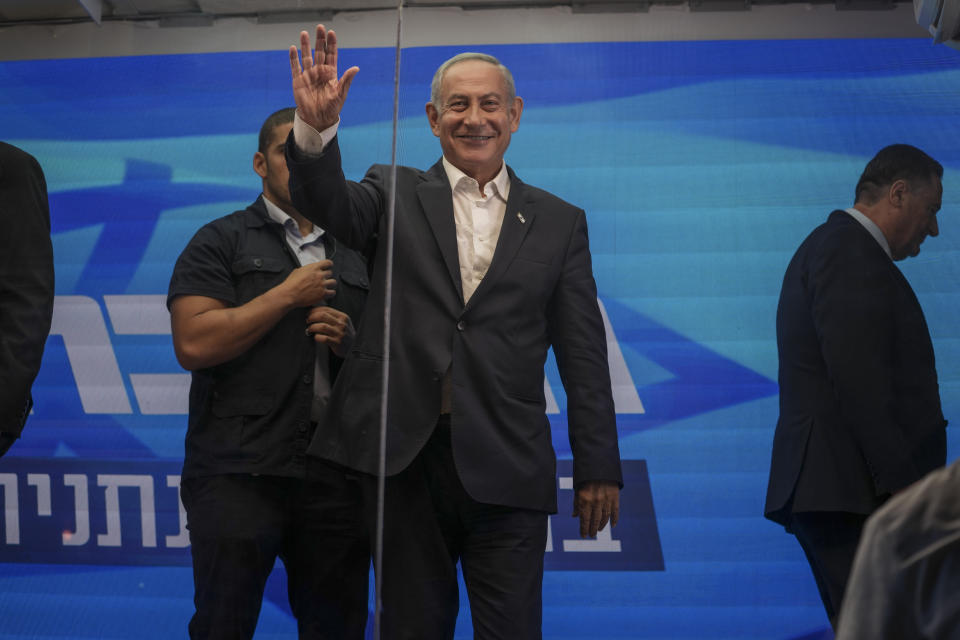 Former Israeli Prime Minister Benjamin Netanyahu waves after delivering an election campaign speech from inside a modified delivery truck with a side wall replaced with bulletproof glass, in Beersheba, southern Israel, Tuesday, Sept. 13, 2022. As he hits the campaign trail for the fifth time in less than four years, Netanyahu is addressing supporters from the strange new vehicle dubbed the “Bibibus" after his popular nickname. (AP Photo/Ariel Schalit)