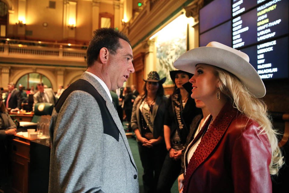 In this Jan. 22, 2014 photo, Colorado state representative Jerry Sonnenberg (R-Sterling) talks with Miss Rodeo America Paige Nicholson, inside the chambers of the Colorado State Legislature, at the Capitol, in Denver. Nicholson was in town for the National Western Stock Show. Sonnenberg, a rancher who’s the only farmer in the Colorado House, plans to push a radical idea this session: give each of his state’s 64 counties one House seat apiece instead of electing representatives from districts with equal populations. ( AP Photo/Brennan Linsley)