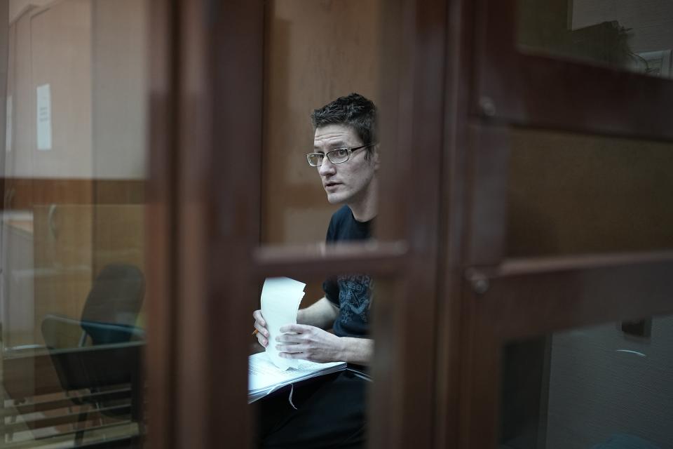 U.S. citizen Robert Woodland Romanov sitss in a cage prior to a court session on drug-related charges in Moscow, Russia, Monday, April 15, 2024. Romanov is facing charges of trafficking large amounts of illegal drugs as part of an organized group — a criminal offense punishable by up to 20 years in prison. (AP Photo/Alexander Zemlianichenko)