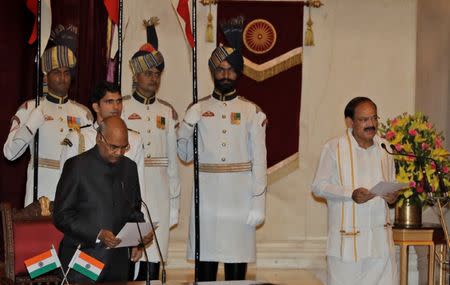 FILE PHOTO: President Ram Nath Kovind (L) administers the oath to the new Vice President Venkaiah Naidu during a swearing-in ceremony at the presidential palace in New Delhi, India August 11, 2017. REUTERS/Manish Swarup/Pool/File Photo