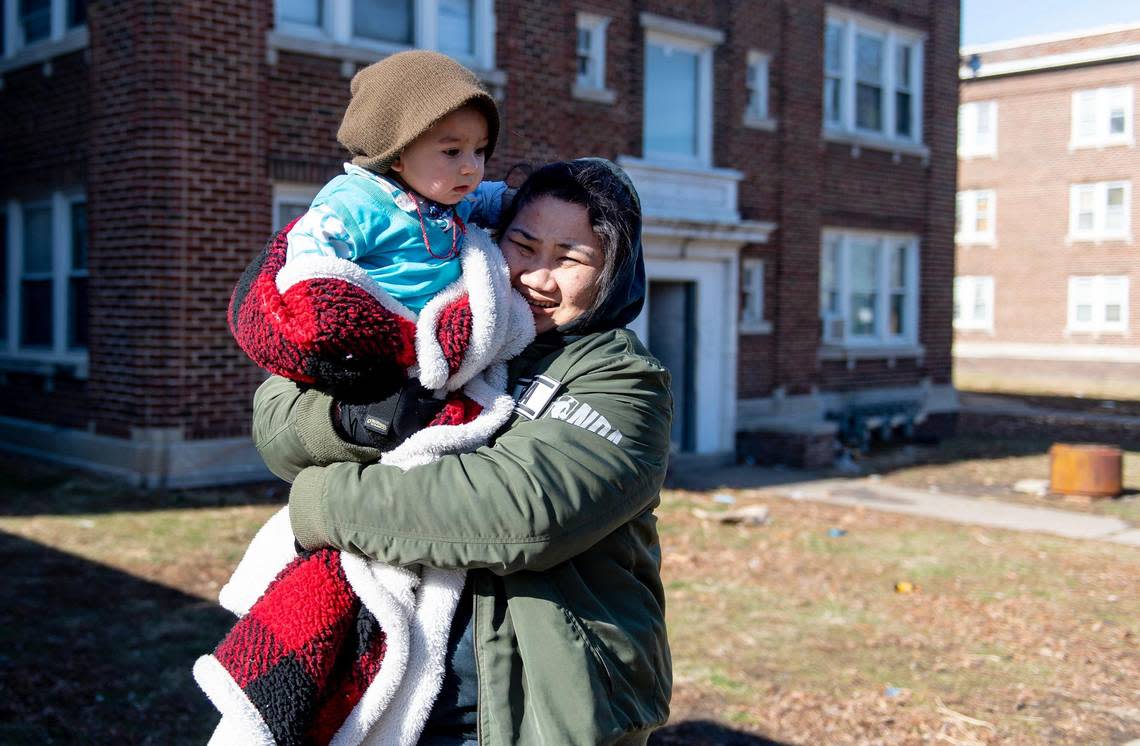 Chaw Noud, a resident that has been without heat since Friday morning, carries her nephew outside of her apartment building on Monday, Jan. 23, 2023, in Kansas City.