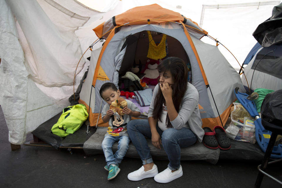 <p>Jeremy Franco Avila, 2, eats Rosca de Reyes or kings’ cake, as he sits with his pregnant mother Carla Ivette Avila Hernandez, 22, in front of the tent where the family has been living since their apartment building was heavily damaged in the Sept. earthquake, in Mexico City, Friday, Jan. 5, 2018. The cakes, along with toys, food, and other gifts, were distributed in celebration of Three Kings Day by Ayudame Hoy, a non-profit civil organization that has been assisting earthquake-displaced populations since September. In Mexico, it is customary for people to give gifts on Three Kings Day every Jan. 6, rather than Christmas Day. (Photo: Rebecca Blackwell/AP) </p>