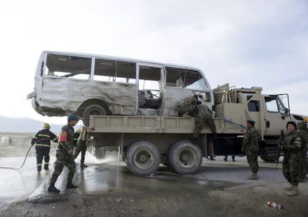 An Afghan National Army truck is used to transport a damaged minibus, which was hit by a suicide attack, on the outskirts of Mazar-i-Sharif, Afghanistan February 8, 2016. REUTERS/ Anil Usyan