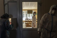 A nurse walks past a red zone as medical workers wearing special suits to protect against coronavirus work there in central district hospital of Kolomyia, western Ukraine, Tuesday, Feb. 23, 2021. After several delays, Ukraine finally received 500,000 doses of the AstraZeneca vaccine marketed under the name CoviShield, the first shipment of Covid-19 vaccine doses. The country of 40 million is one of the last in the region to begin inoculating its population. (AP Photo/Evgeniy Maloletka)