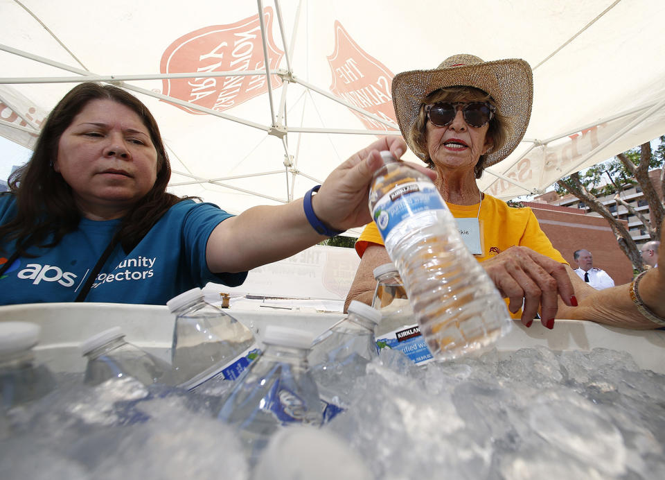 <p>Salvation Army volunteers Evangeline Ford, left, and Jackie Rifkin, right, restock a cooler with bottles of water at a hydration station for people as they try to keep hydrated and stay cool as temperatures climb to near-record highs, June 19, 2017, in Phoenix. (Ross D. Franklin/AP) </p>