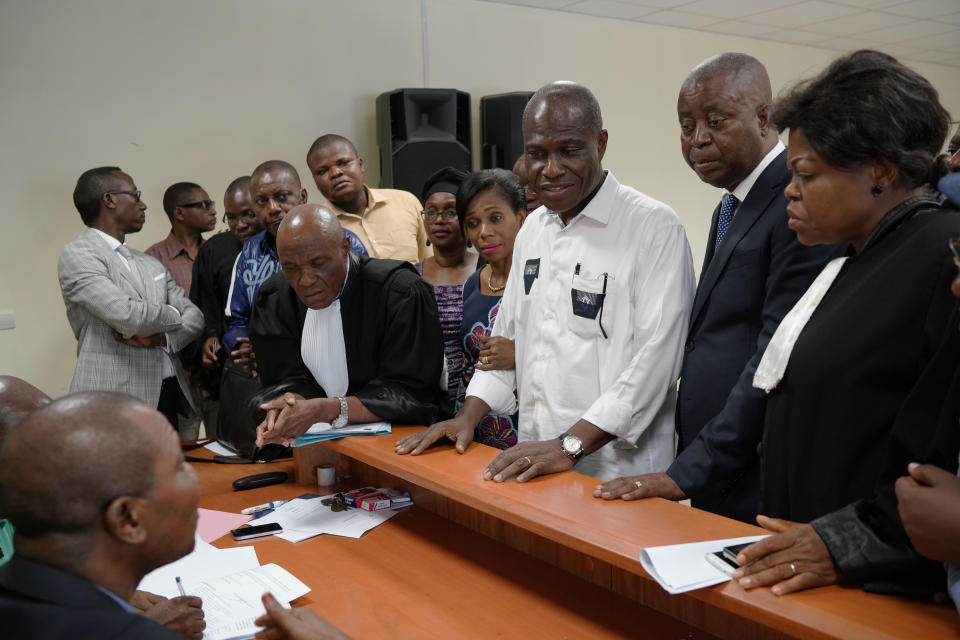 Accompanied by his wife and his lawyers, Congo opposition candidate Martin Fayulu, center, petitions the constitutional court following his loss in the presidential elections in Kinshasa, Congo, Saturday Jan. 12, 2019. The ruling coalition of Congo's outgoing President Joseph Kabila has won a large majority of national assembly seats, the electoral commission announced Saturday, while the presidential election runner-up was poised to file a court challenge alleging fraud. (AP Photo/Jerome Delay)