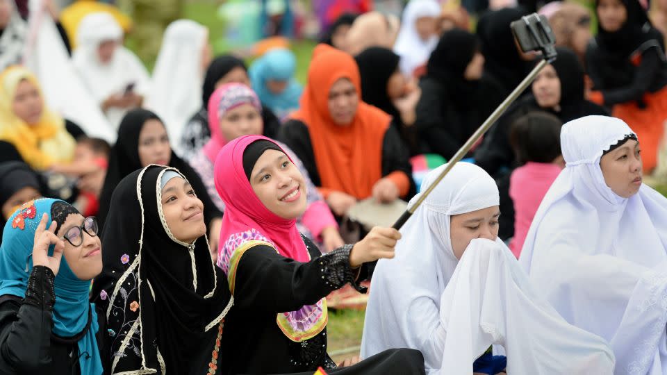 Young Muslims devotees take a selfie before Friday prayers to mark the end of Ramadan in Manila, Philippines. - TED ALJIBE/AFP/Getty Images