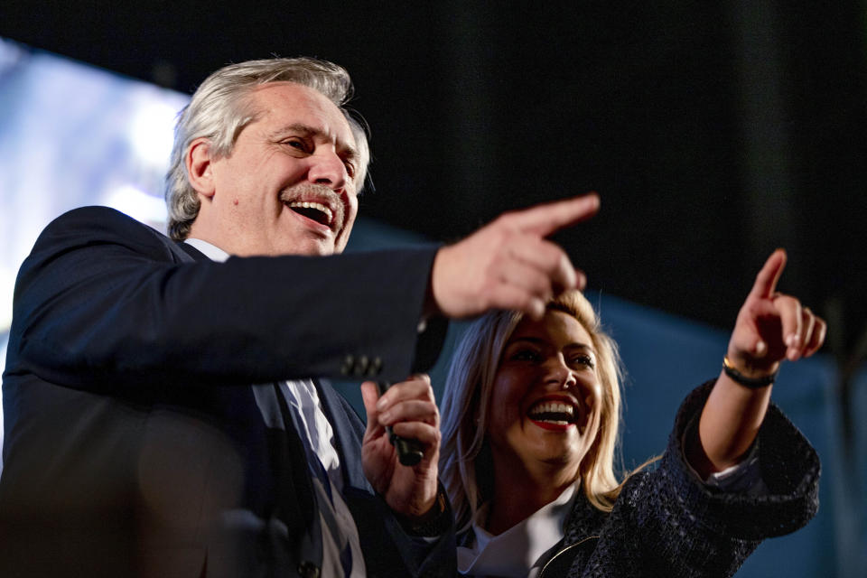 Presidential candidate Alberto Fernandez, left, addresses supporters next to his partner Fabiola Yanez outside the "Frente de Todos" party headquarters after primary elections in Buenos Aires, Argentina, Sunday, Aug. 11, 2019. The "Frente de Todos" presidential ticket with former President Cristina Fernández emerged as the strongest vote-getter in Argentina's primary elections Sunday, indicating conservative President Mauricio Macri will face an uphill battle going into general elections in October.(AP Photo/Tomas F. Cuesta)