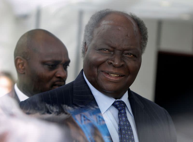 FILE PHOTO: Kenya's President Mwai Kibaki walks behind a glass wall as he arrives for the inauguration of the new African Union building in Addis Ababa
