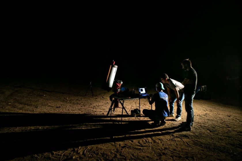 JOSHUA TREE, CA - JUNE 23: (Left to Right) Patrick Kelly, DRAGRACER Program Manager, Ian Silverberg, 2021 Astrodynamics and Analysis Intern and Tyler Ritz, Optical Communications Engineer attempt to locate the DRAGRACER satellite during a break in the clouds in Joshua Tree on Wednesday, June 23, 2021 in Joshua Tree, CA. (Jason Armond / Los Angeles Times)