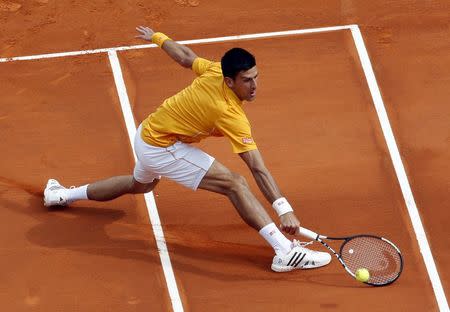 Novak Djokovic of Serbia returns the ball to Rafael Nadal of Spain during their semi-final match at the Monte Carlo Masters in Monaco April 18, 2015. REUTERS/Jean-Paul Pelissier