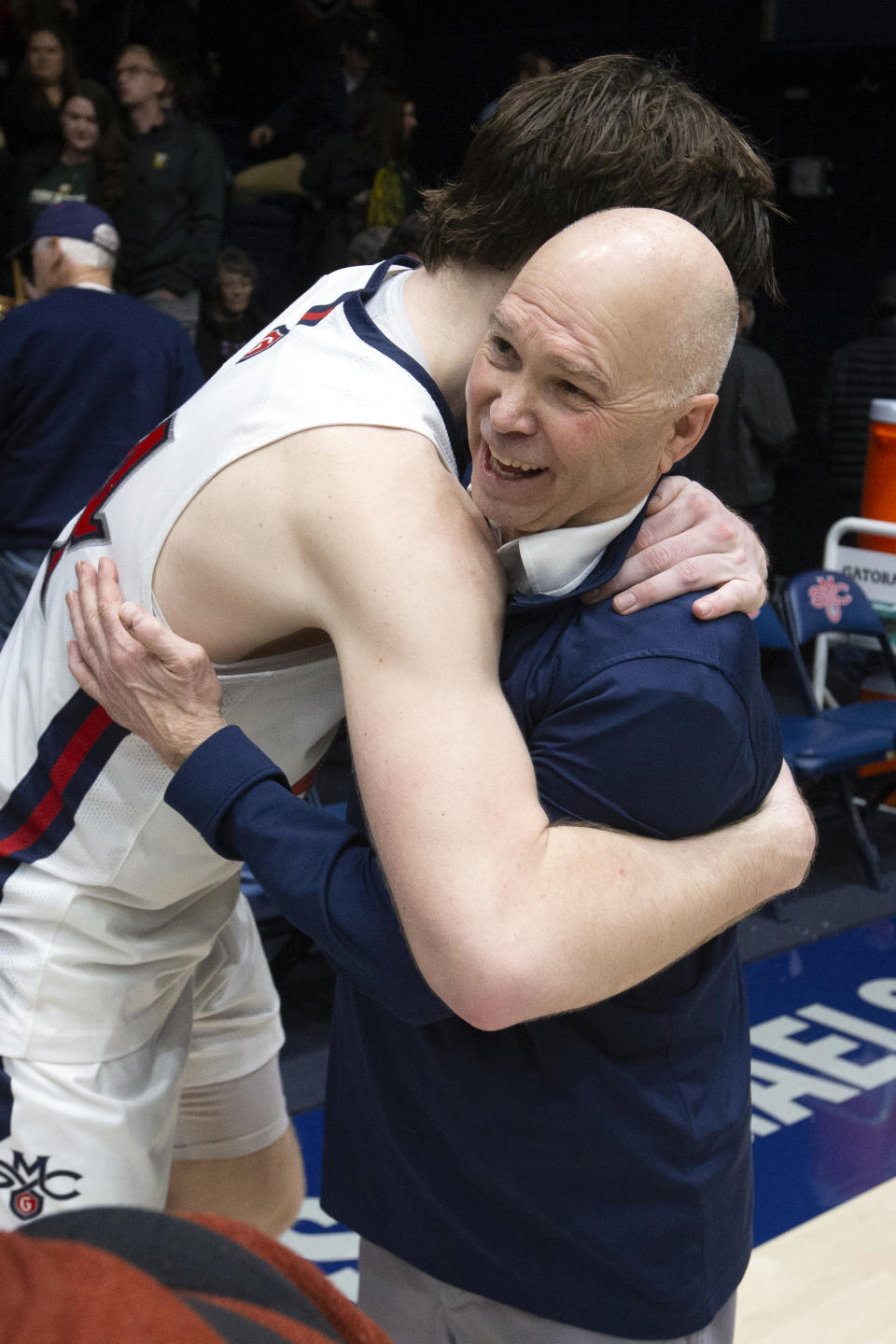 Saint Mary's head coach Randy Bennett, right, gets a hug from guard Alex Ducas (44) after notching his 500th career coaching victory, with a 68-59 victory over San Francisco in an NCAA college basketball game, Thursday, Feb. 2, 2023, in Moraga, Calif. (AP Photo/D. Ross Cameron)
