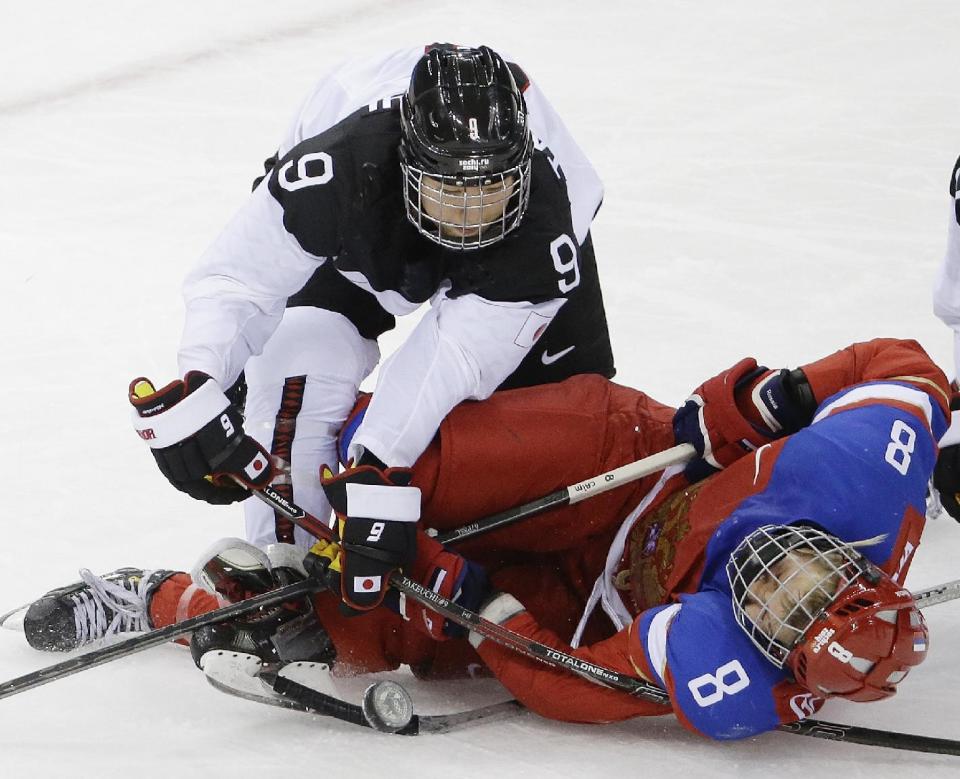 Aina Takeuchi of Japan collides with Iya Govrilova of Russia during the third period of the 2014 Winter Olympics women's ice hockey game at Shayba Arena, Tuesday, Feb. 11, 2014, in Sochi, Russia. Russia defeated Japan 2-1. (AP Photo/Mark Humphrey)