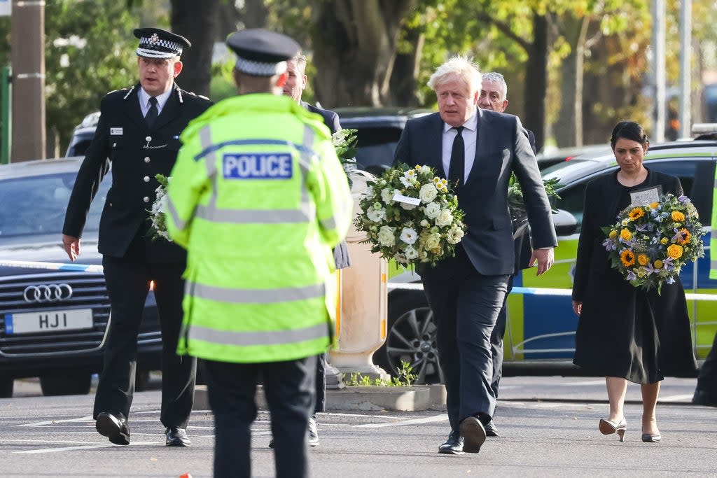 Chief Constable Ben-Julian Harrington, Labour leader Sir Keir Starmer, Prime Minister Boris Johnson and Home Secretary Priti Patel carry flowers as they arrive at the scene near Belfairs Methodist Church in Leigh-on-Sea, Essex, where Conservative MP Sir David Amess died after he was stabbed several times at a constituency surgery on Friday. (Dominic Lipinski/PA) (PA Wire)