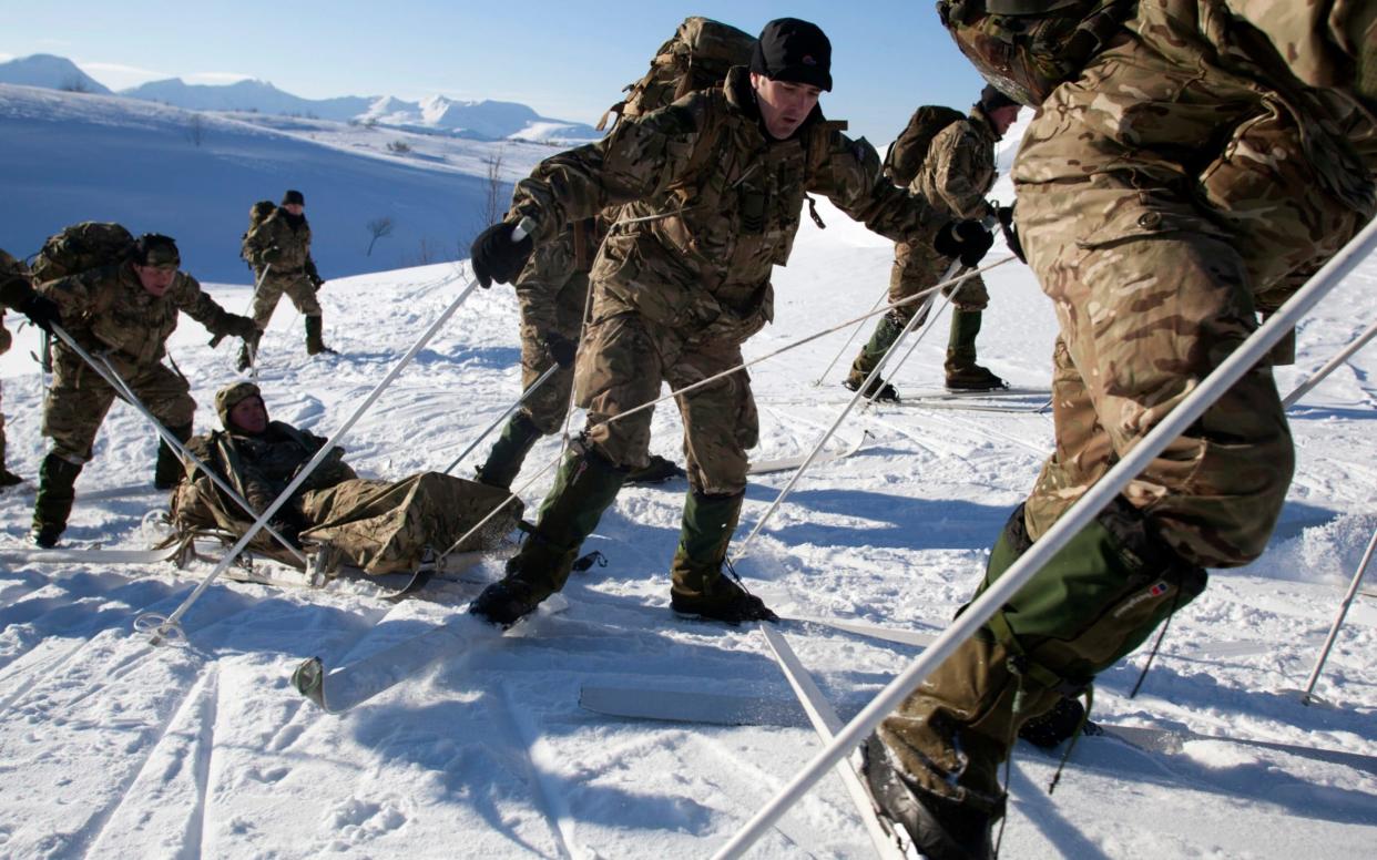 British Royal Marines pull and push a sled bearing one of their own during medevac exercises in the Arctic Circle - Getty Images Europe