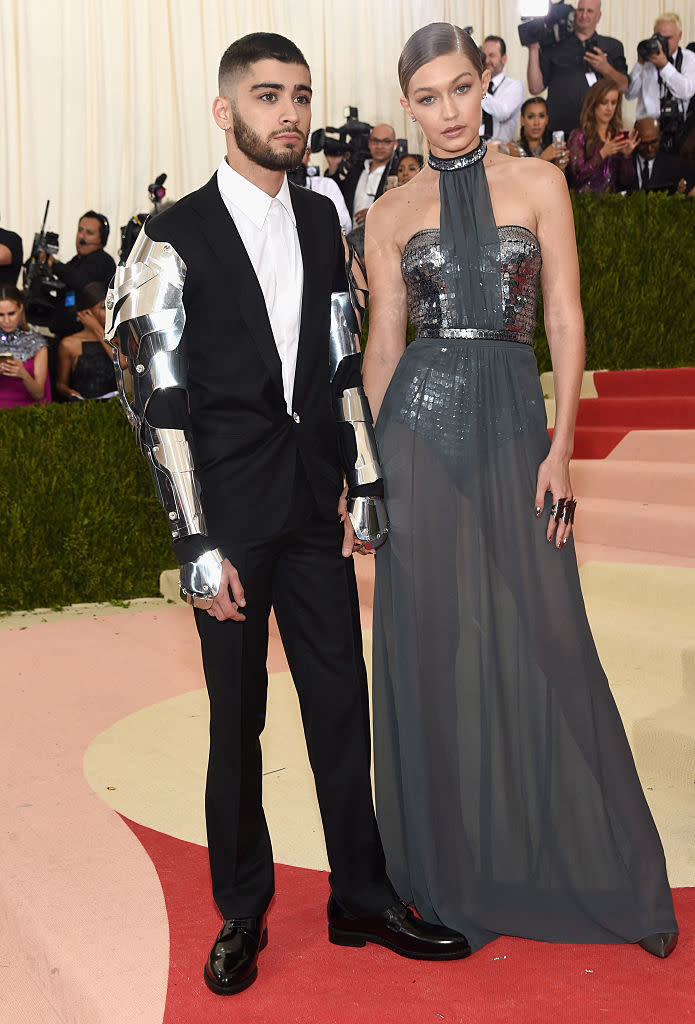 Zayn Malik in a suit with metallic arm sleeves, Gigi Hadid in a gown with sequins, posing together on the red carpet