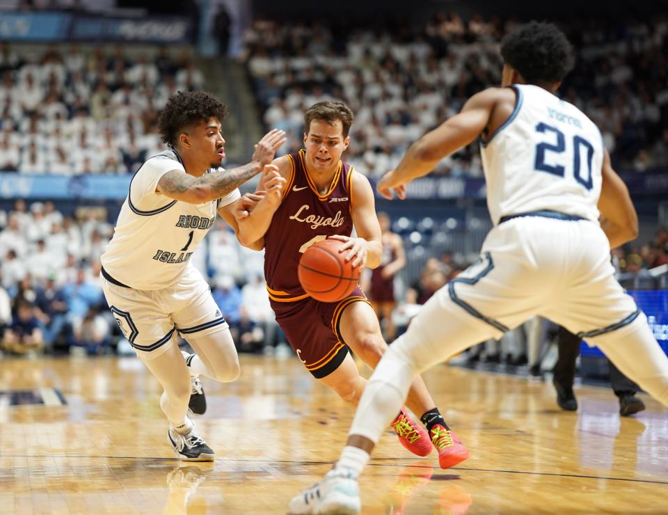 Loyola Chicago's Braden Norris looks to drive past the Rhode Island defense — Luis Kortright, left, and Brandon Weston — on Sunday afternoon at the Ryan Center.