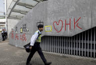 A police officer passes by "Love Hong Kong" words formed with tape near the Legislative Council in Hong Kong on Friday, June 14, 2019. Calm appeared to have returned to Hong Kong after days of protests by students and human rights activists opposed to a bill that would allow suspects to be tried in mainland Chinese courts. (AP Photo/Vincent Yu)