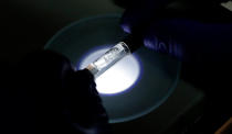 A Yolo! brand CBD vape oil cartridge is examined at Flora Research Laboratories in Grants Pass, Ore., on July 17, 2019. The Associated Press commissioned the lab to test that vape and 29 others as part of an investigation that shows a dark side to the booming industry selling the cannabis extract CBD. The Yolo cartridge and nine other samples contained synthetic marijuana, a dangerous street drug commonly known as K2 or spice. (AP Photo/Ted Warren)