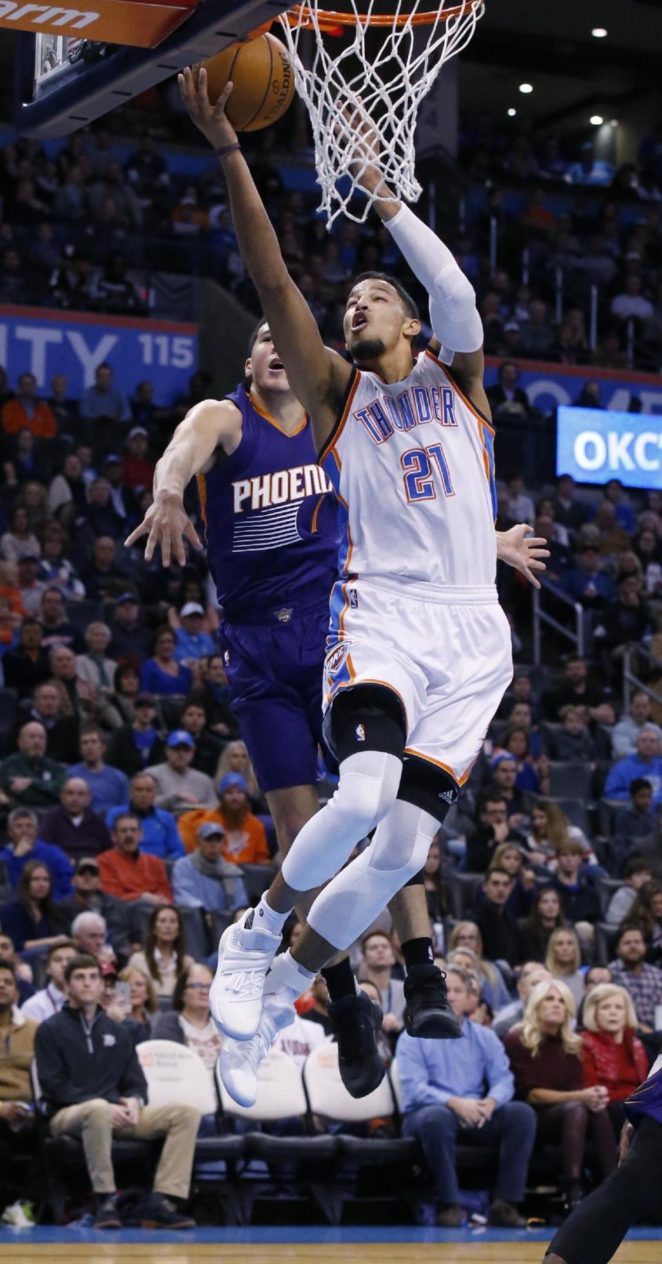 Oklahoma City Thunder forward Andre Roberson (21) shoots in front of Phoenix Suns guard Devin Booker (1) in the first quarter of an NBA basketball game in Oklahoma City, Saturday, Dec. 17, 2016. (AP Photo/Sue Ogrocki)