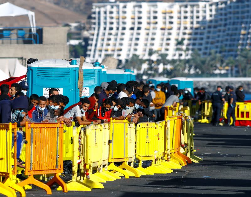 Migrants rest after being rescued by coast guards or reached the island by their own means, in the Arguineguin harbour