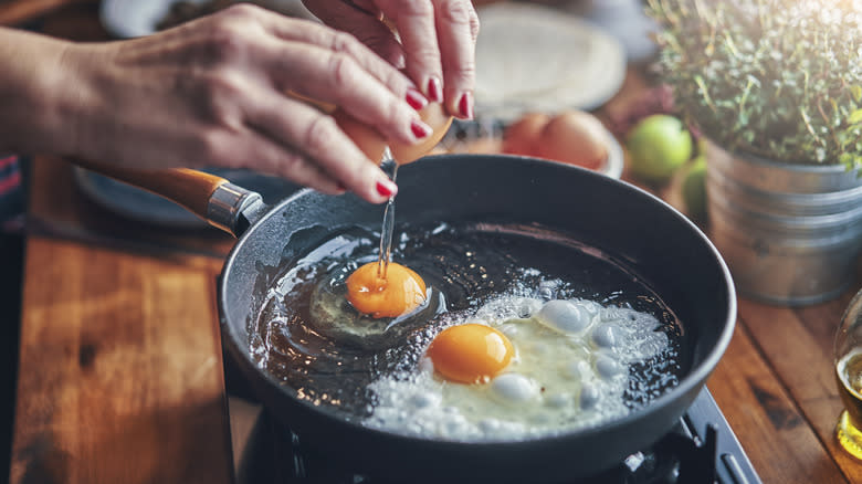 cracking egg in skillet