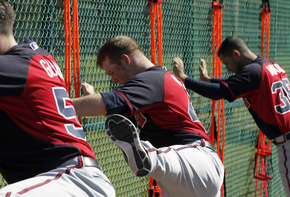 Atlanta Braves pitcher Craig Kimbrel, center, does leg swings during a spring training baseball workout on Sunday, Feb. 16, 2014, in Kissimmee, Fla. The Braves agreed to terms with Kimbrel on a four-year contract. (AP Photo/Alex Brandon)