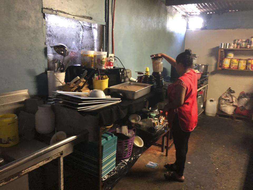Honduran migrant Dunea Romero, 31, helps helps make Honduran style nachos at the migrant shelter where she is living in Tijuana, Mexico, as she waits for her next asylum hearing in the U.S., Thursday, Sept. 12, 2019, on the border with San Diego. Romero, who was married to a powerful gang leader, grabbed passports for herself and two boys, ages 7 and 11, packed a bag and left the morning after a friend told her that her ex-husband had a hit out on her life. (AP Photo/Julie Watson)