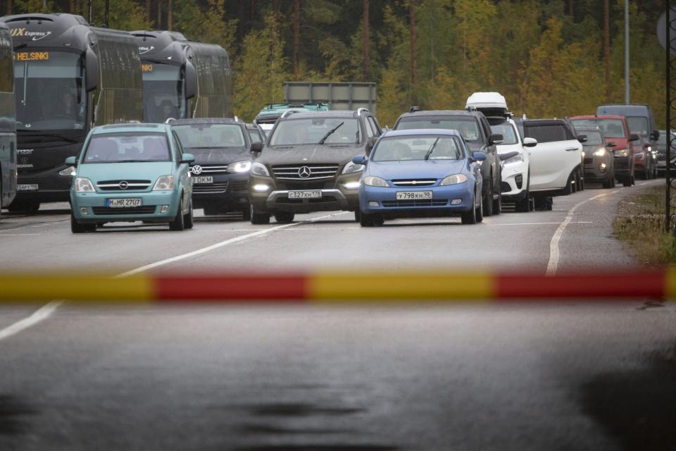 Russian cars and buses line up at the Vaalimaa border check point between Finland and Russia in Virolahti, Finland, Friday, Sept. 30, 2022. The Finnish-Russia border was closed Friday after the Nordic country announced it would ban Russians with tourist visas from entering, curtailing one of the last easily accessible routes to Europe for Russians trying to flee a military mobilization. Long queues were reported until midnight and among the last to enter Finland were two cyclists who arrived a little before 11 p.m., Finnish broadcaster YLE reported. (Sasu Makinen./Lehtikuva via AP)