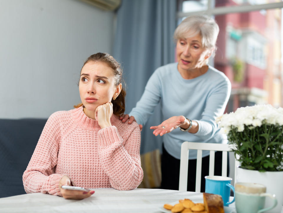 An older woman scolding a younger woman on her phone