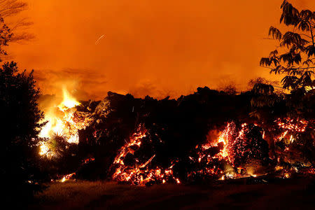 Lava from the Kilauea volcano eruption crosses Kahukai St. in the Leilani Estates near Pahoa, Hawaii, U.S., May 25, 2018. REUTERS/Marco Garcia