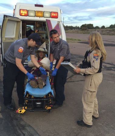 Ann Charon Rogers is assisted by rescuers on the White River Indian Reservation in Gila County, Arizona in this handout photo provided by the Arizona Department of Safety April 12, 2016. REUTERS/Arizona Department of Safety/Handout via Reuters