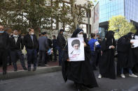 A demonstrator holds a portrait of the Iranian Supreme Leader Ayatollah Ali Khamenei in a rally in front of the former U.S. Embassy commemorating the anniversary of its 1979 seizure in Tehran, Iran, Thursday, Nov. 4, 2021. The embassy takeover triggered a 444-day hostage crisis and break in diplomatic relations that continues to this day. (AP Photo/Vahid Salemi)