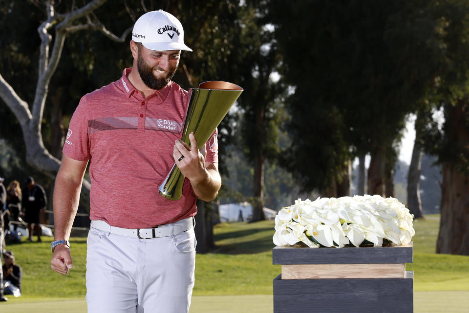 Jon Rahm hold the winner's trophy after winning the Genesis Invitational golf tournament at Riviera Country Club, Sunday, Feb. 19, 2023, in the Pacific Palisades area of Los Angeles. (AP Photo/Ryan Kang)