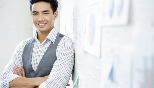 Portrait of young man in office next to wall presentation