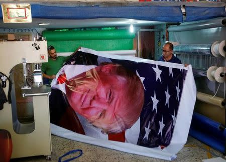 Palestinians print a poster depicting U.S. President Donald Trump in preparations for his planned visit, in the West Bank town of Bethlehem May 21, 2017. REUTERS/Mussa Qawasma