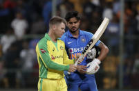 Australia's David Warner, left, checks out the bat of India's Manish Pandey after India won the third one-day international cricket match between India and Australia in Bangalore, India, Sunday, Jan. 19, 2020. (AP Photo/Aijaz Rahi)