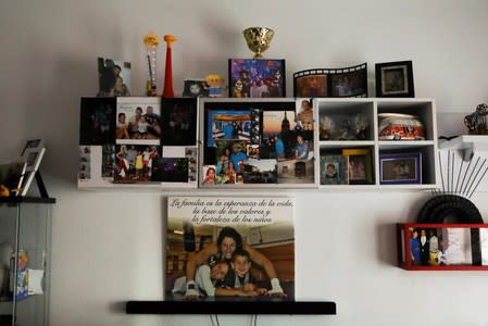 A picture of Miriam Gutierrez with her kids on the ring of her boxing gym is displayed with the phrase "Family is life's hope, the base for values and the strength for children" on the wall of her living room in Torrejon de Ardoz