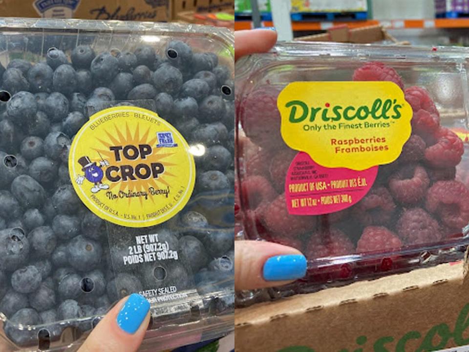 hand holding carton of blueberries and hand holding carton of raspberries at costco