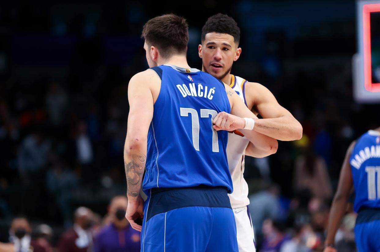 Jan 20, 2022; Dallas, Texas, USA; Dallas Mavericks guard Luka Doncic (77) hugs Phoenix Suns guard Devin Booker (1) after the game at American Airlines Center.