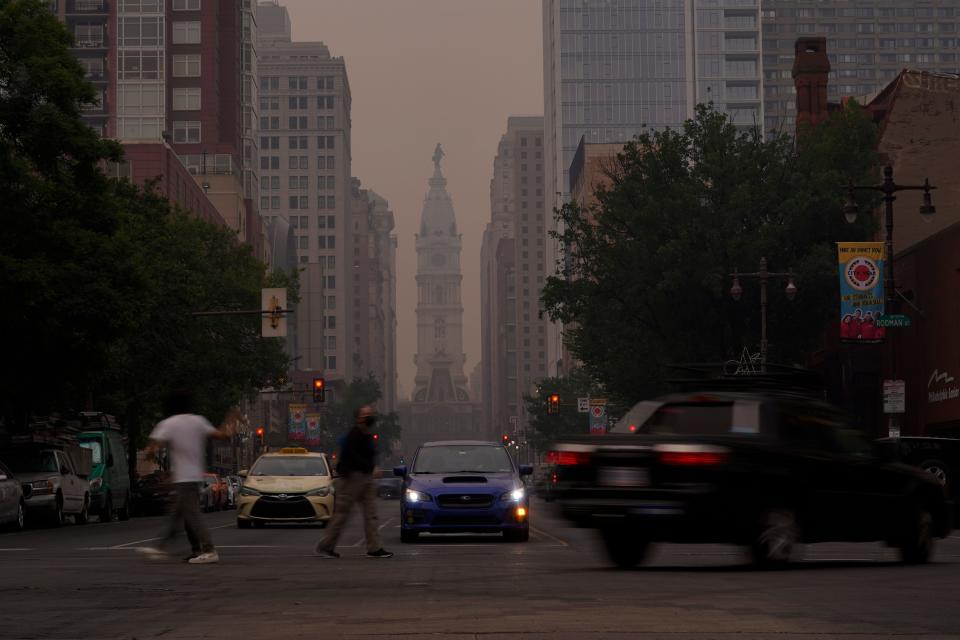 Evening commuters travel on Broad Street past a hazy City Hall, Wednesday, June 7, 2023, in Philadelphia.  Smoke from Canadian wildfires poured into the U.S. East Coast and Midwest on Wednesday, covering the capitals of both nations in an unhealthy haze, and prompting people to fish out pandemic-era face masks.