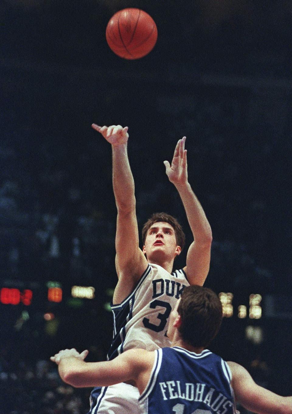 FILE - Duke's Christian Laettner shoots the game-winning basket in overtime over University of Kentucky's Deron Feldhaus to win the NCAA East Finals in Philadelphia, March 28, 1992. Duke beat Kentucky 104-103. (AP Photo/Charles Arbogast, File)