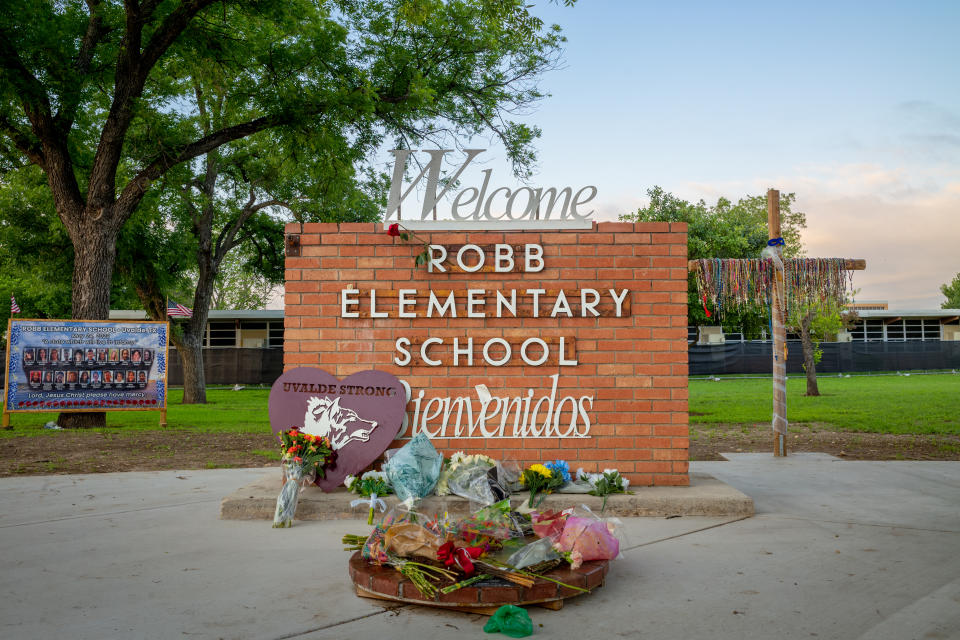 Flowers are seen next to the entrance of Robb Elementary School.