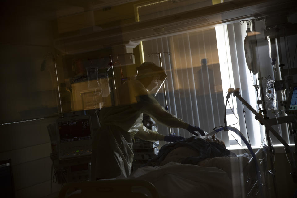 In this photo taken on Friday, April 24, 2020, a medical staffer works in the intensive care ward for COVID-19 coronavirus patients at the Jessa Hospital in Hasselt, Belgium. The Jessa Hospital in Hasselt, Belgium, has shared a large brunt of the patient load in their ICU unit. The hospital is located in the Limburg region which has been one of the hardest hit in the country by the virus. (AP Photo/Francisco Seco)