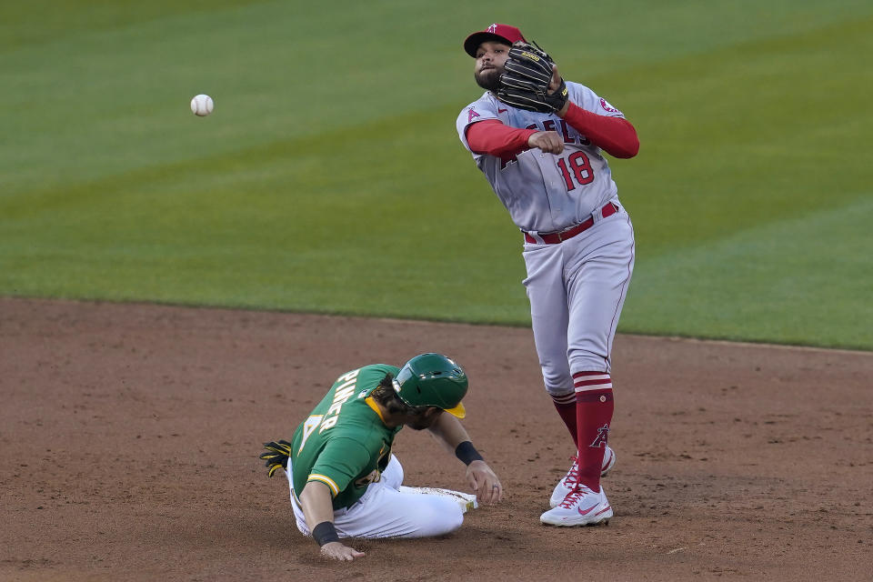 Los Angeles Angels second baseman Jose Rojas (18) throws to first base after forcing out Oakland Athletics' Chad Pinder at second base on a double play hit into by Ramon Laureano during the third inning of a baseball game in Oakland, Calif., Thursday, May 27, 2021. (AP Photo/Jeff Chiu)